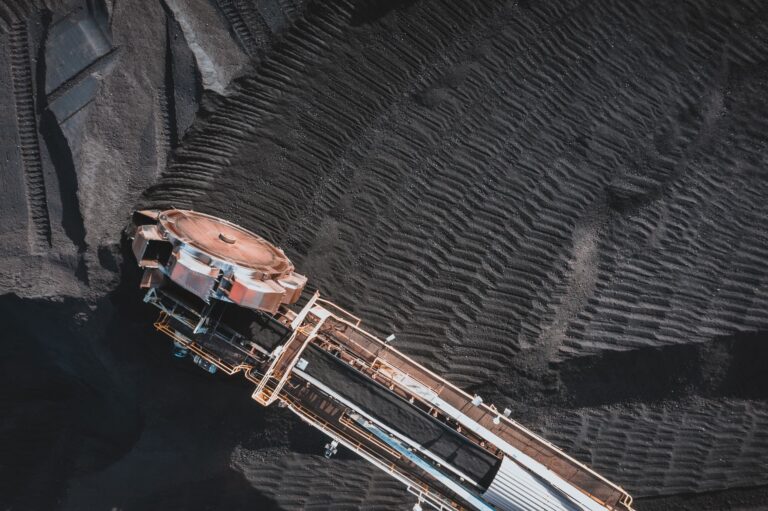 From above of industrial machine with conveyor belts digging and transporting coal in daylight